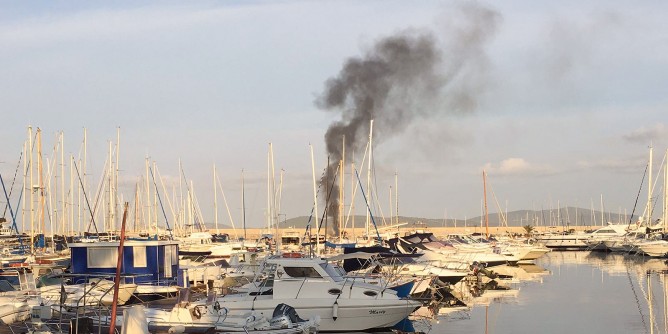 Barca in <i>fumo</i> nel porto di Alghero