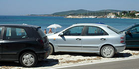 Spiagge di Alghero aggredite dai bagnanti. Auto parcheggiate sulla sabbia a pochi passi dal bagnasciuga